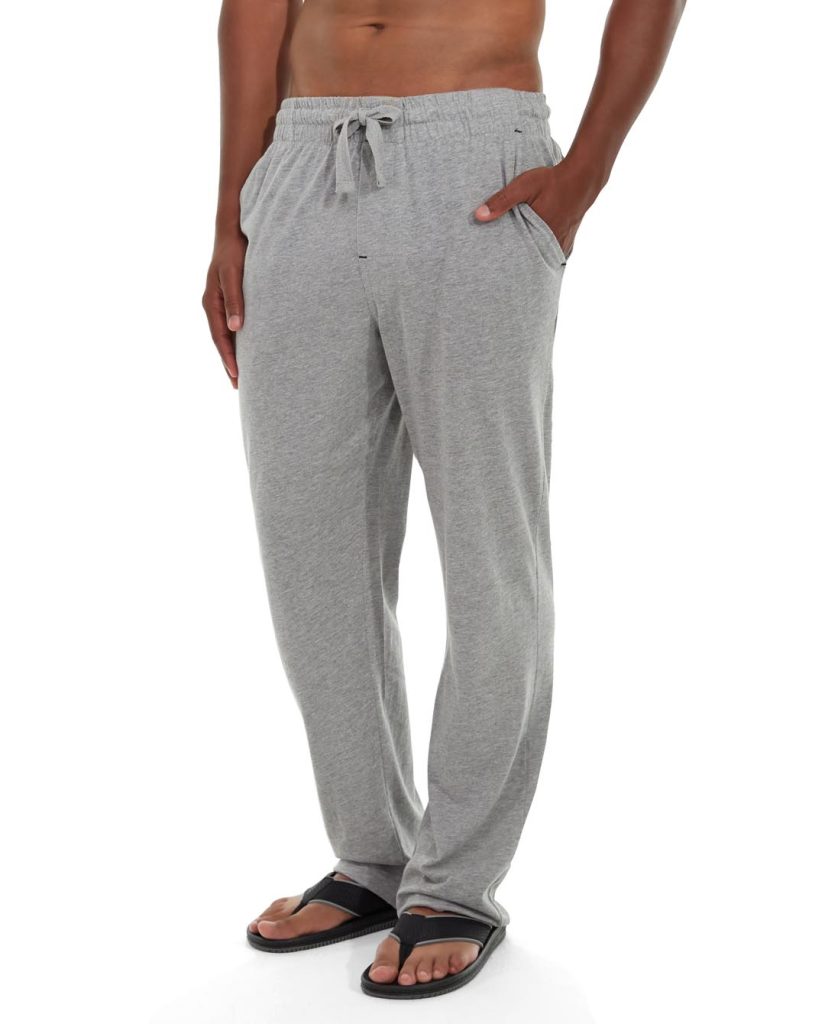 Male athlete stretching in olive green performance warm-up pants with athletic stance
