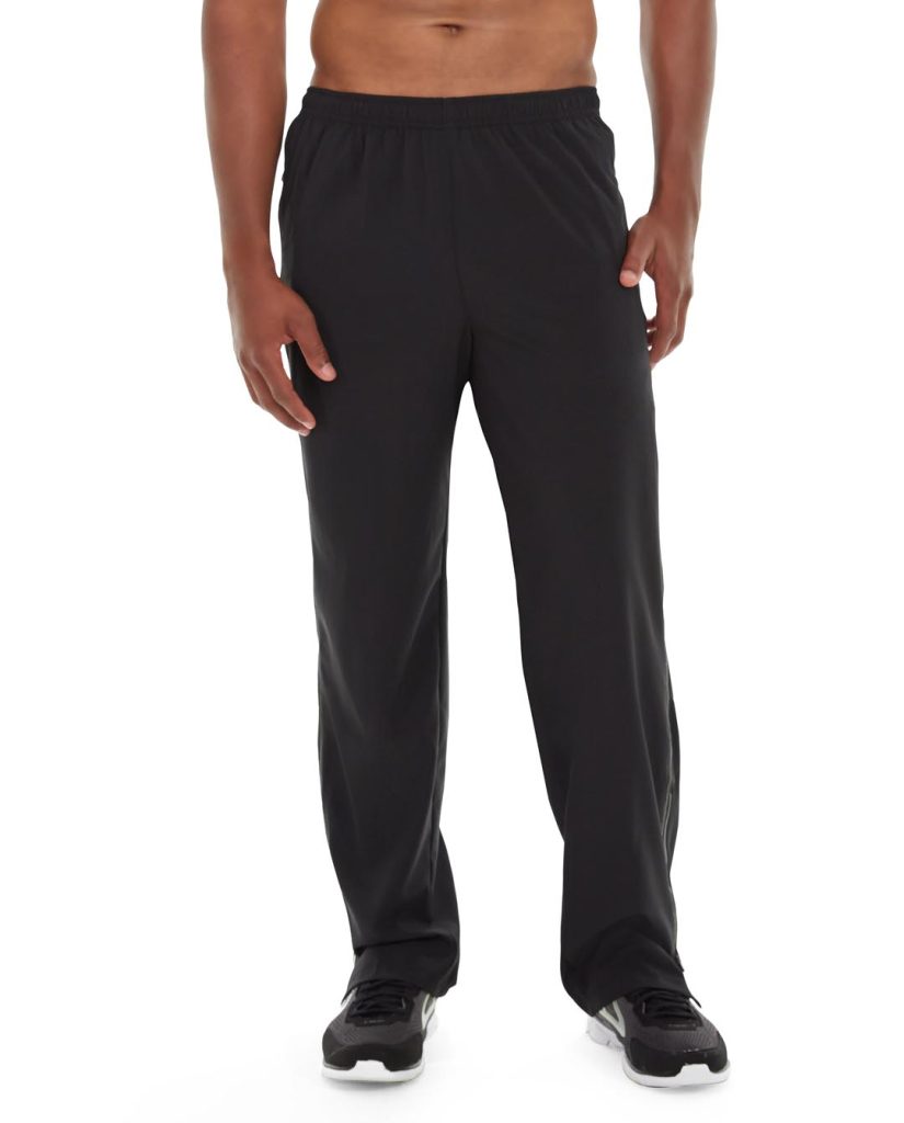 Male runner wearing black insulated joggers, running on a cold, windy trail