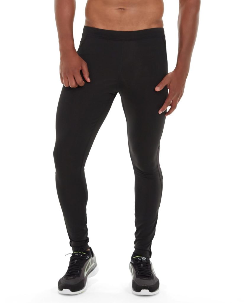 Woman stretching in versatile black athletic tights during outdoor mountain climbing activity