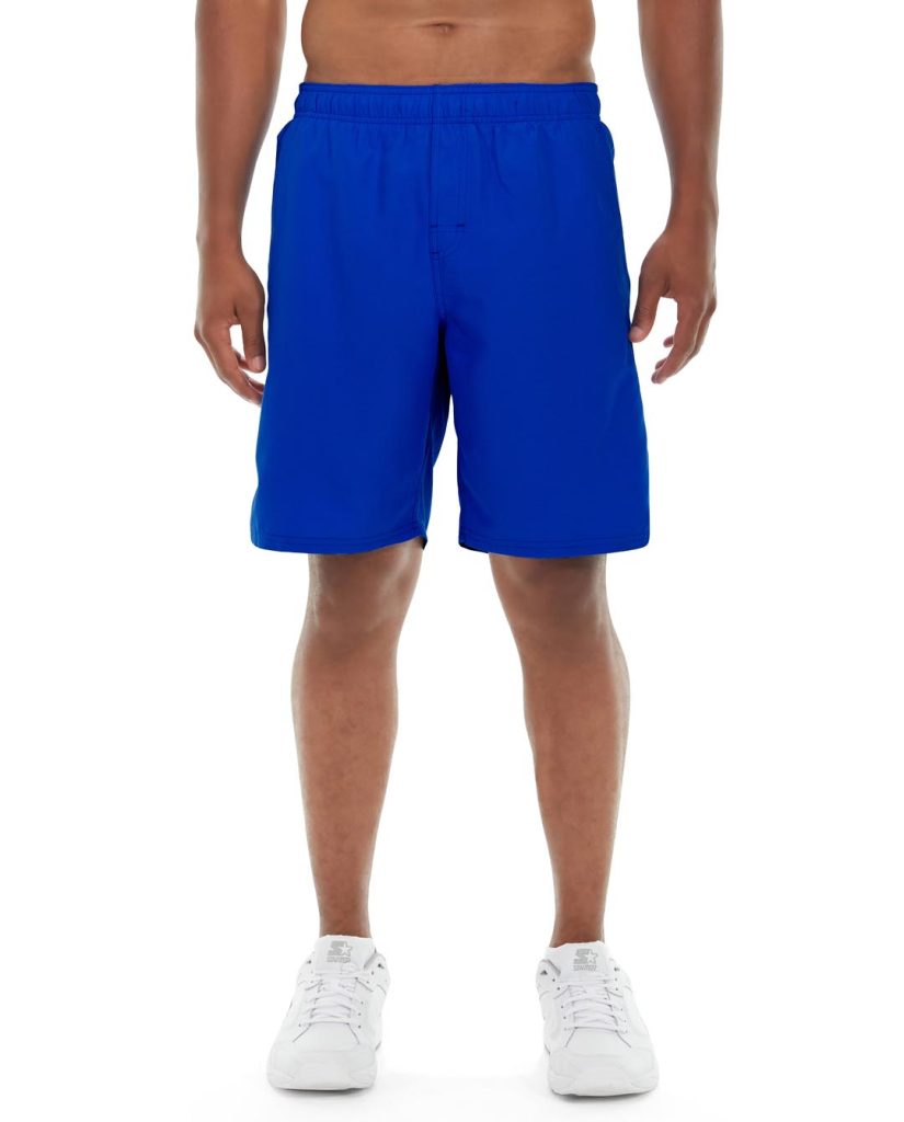 Male athlete wearing blue performance shorts, running outdoors in sunny environment