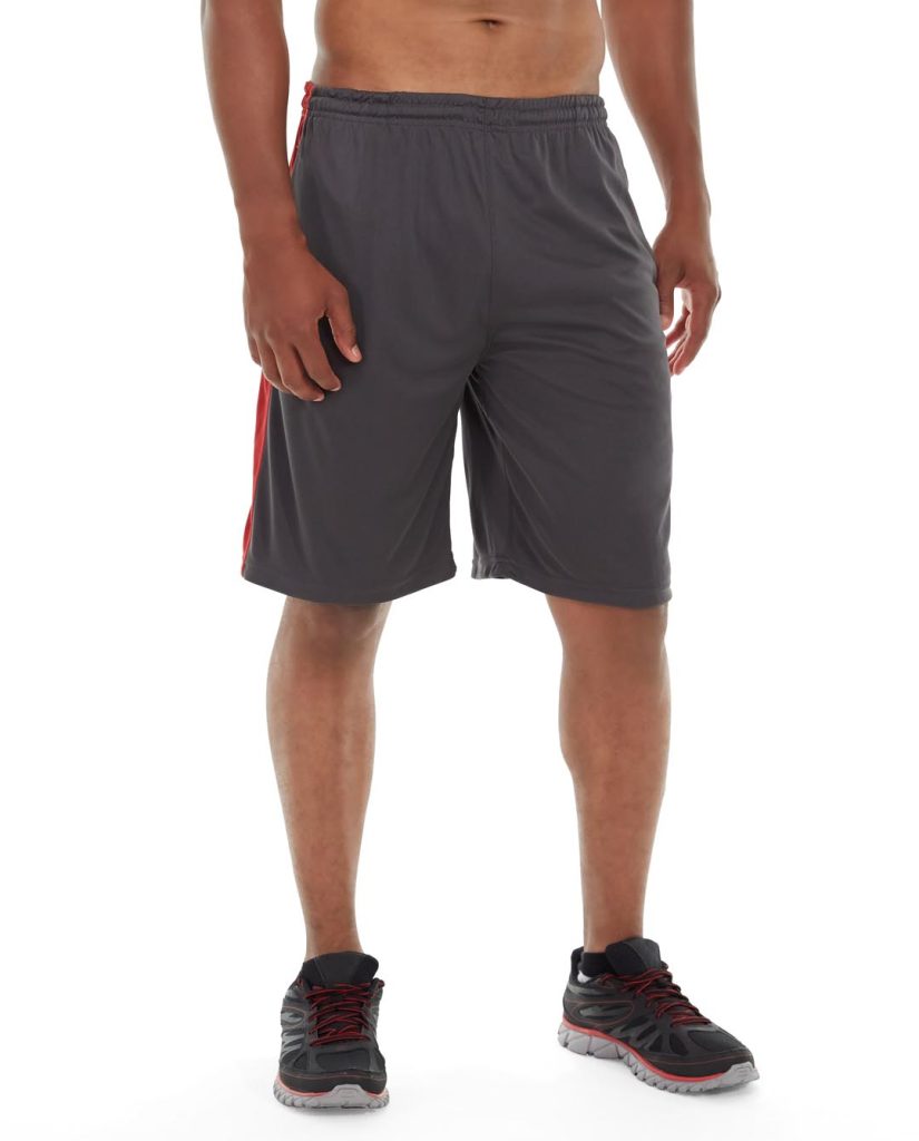 Woman in gray yoga shorts doing a stretching pose against minimalist background